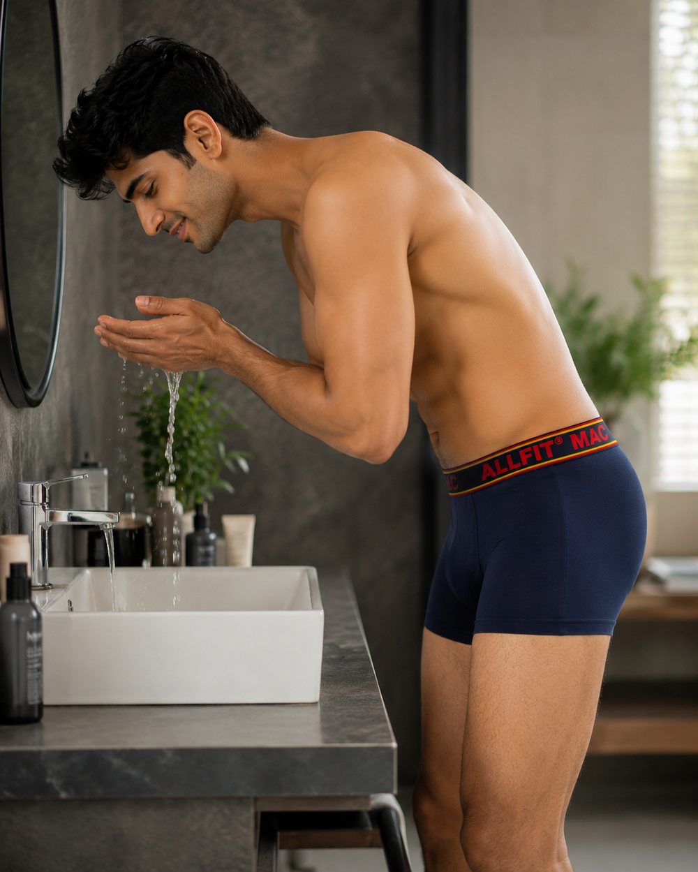 Man washing his face at the bathroom sink wearing ALLFiT MAC trunk